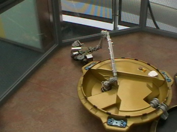 This is the Beagle 2. Photograph taken in 2009 at the National Space Centre, Leicester, UK.  This was a machine designed to be sent to Mars and to use the instruments on board to send data back to Earth as to the composition and makeup of the red Planet. Of course, it could be anything at all for your fiction piece, it does not have to be the Beagle 2